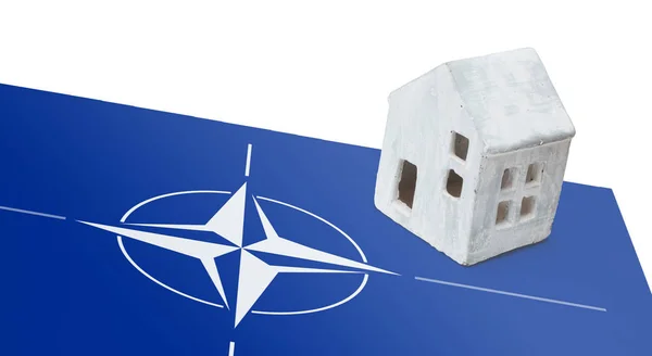 Small house on a flag - NATO — Stock Photo, Image