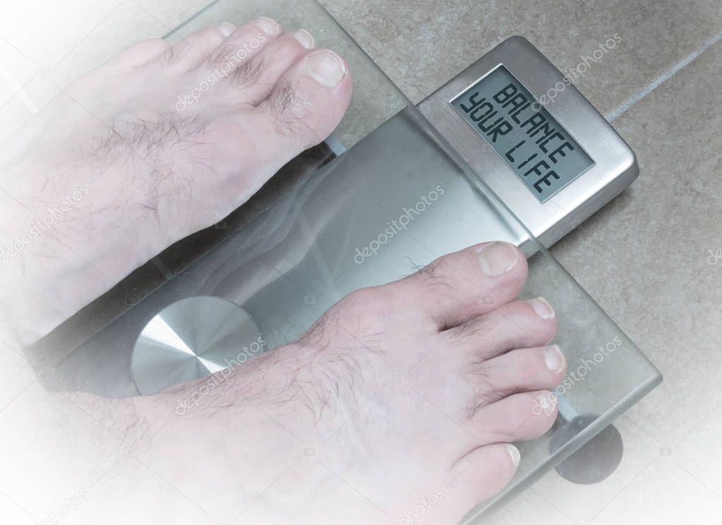 Man's feet on weight scale - Balance your life
