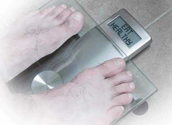 Mužská chodidla na hmotnosti v měřítku - jíst zdravě — Stock fotografie