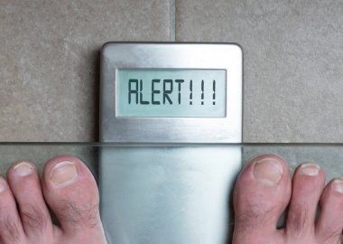 Adamın ayakları üzerinde ağırlık ölçek - uyarı