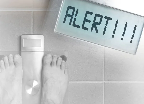 Man\'s feet on weight scale - Alert