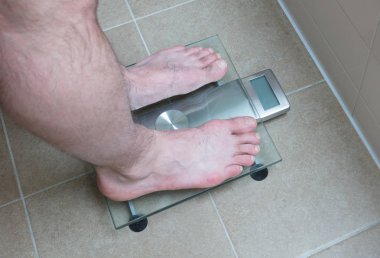 Adamın ayakları üzerinde ağırlık ölçek - 