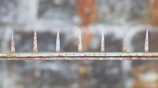 Spiked fence, rusty old spikes — Stock Photo, Image