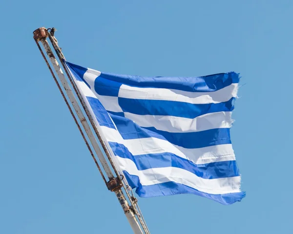 Griekse vlag zwaaien onder heldere hemel — Stockfoto