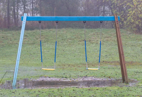 Plastikschaukel hängt über einer Pfütze — Stockfoto