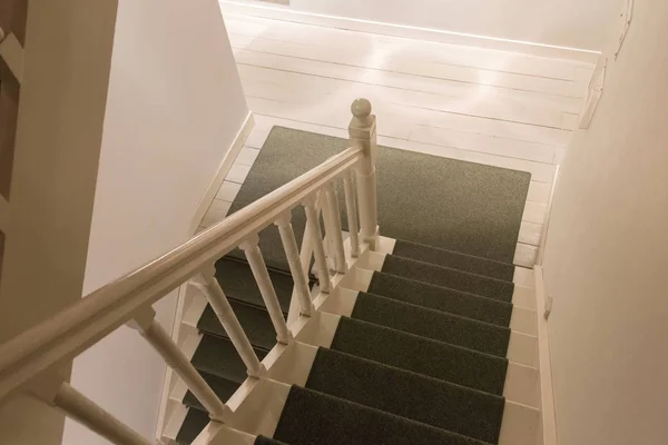 Weiße Holztreppe mit grünem Teppich — Stockfoto