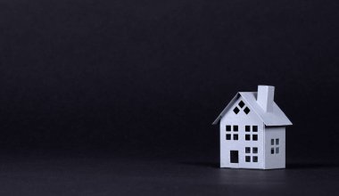 Emlak kavramı, siyah arka planda izole edilmiş metal ev