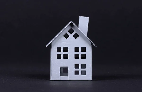 Концепция недвижимости, металлический дом на черном фоне — стоковое фото