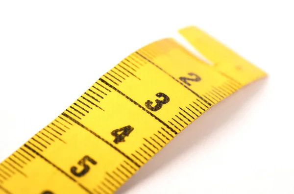 Close-up of a yellow measuring tape isolated on white - 3 Stock Photo