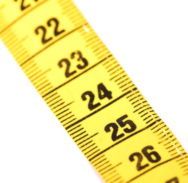 Close-up of a yellow measuring tape isolated on white - 24 - Selective focus