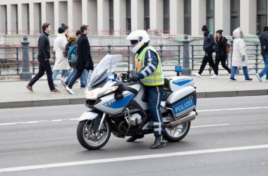 Berlin, Germany - August 31, 2019: German policewoman and her BMW motorcycle in the middle of the street.