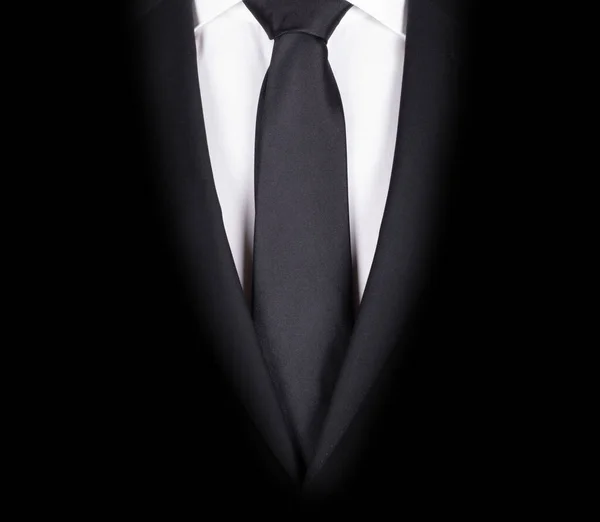 Man in a black suit with black tie, close-up