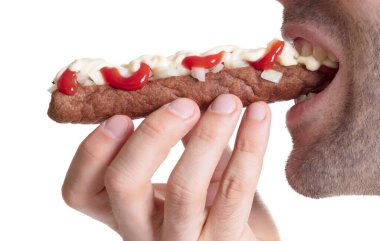 Ketçaplı frikadel yiyen bir adam, doğranmış soğanlı mayonez, 'frikadel spesiyali' denen Hollanda fast food atıştırması.