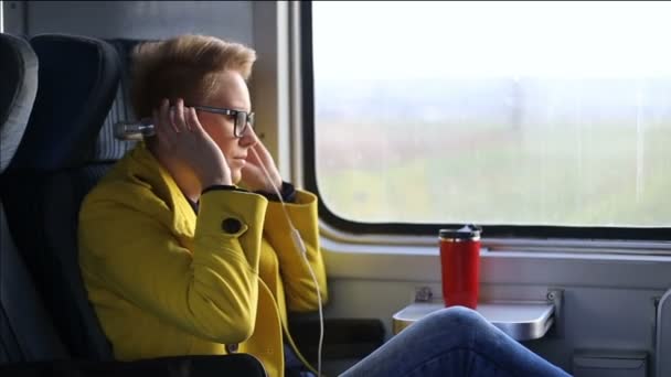 きれいな女性電車に乗ってスマート フォンでヘッドフォンで音楽を聴いて 市バスに乗ると美しい少女 — ストック動画