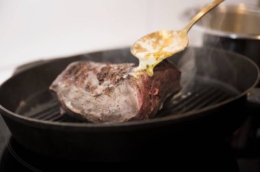 Tavada orta boy biftek üzerine sos.