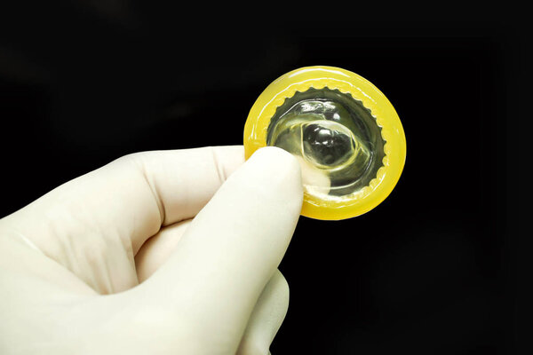 Врач сдал медицинскую латексную перчатку, подобрав презерватив изолировать на черном фоне и сделать с дорожками
.