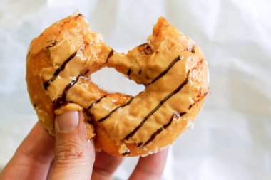 Fıstık ezmesi halka kaba beyaz kağıt arka plan üzerinde yemiş oldu tutan el.