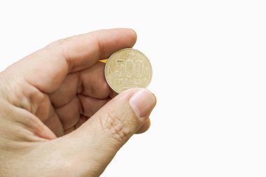 Beyaz arka plan üzerinde 500 Yen Japon para tutan el izole.