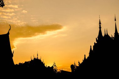 Yakın çekim ve hasat silueti. Tayland tapınağının altın güneş batımında gökyüzü arkaplanı..