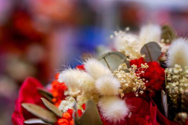 Bulanık arkaplanda kurumuş ve kağıt suni çiçeklerin yakın plan ve kırpma renkli dekoratifi.