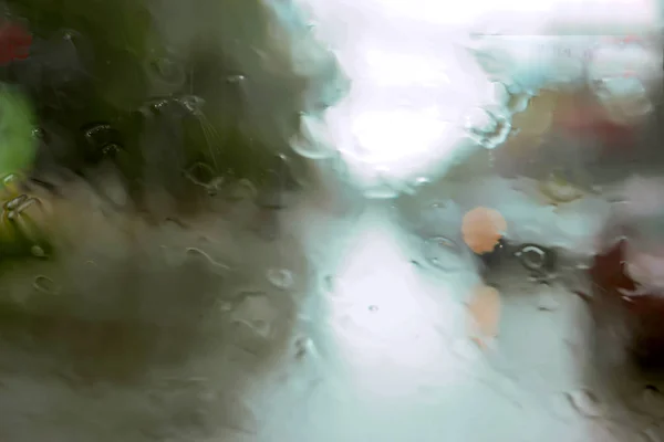 Driver ogen uitzicht op regendruppels op auto voorruit op regenachtige dag. — Stockfoto