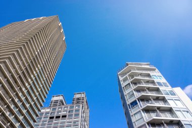 Osaka, Japonya-18 Ocak 2019: Parlak mavi gökyüzü ve parlak arka plandaki şehir binalarının manzarası ve manzarası.