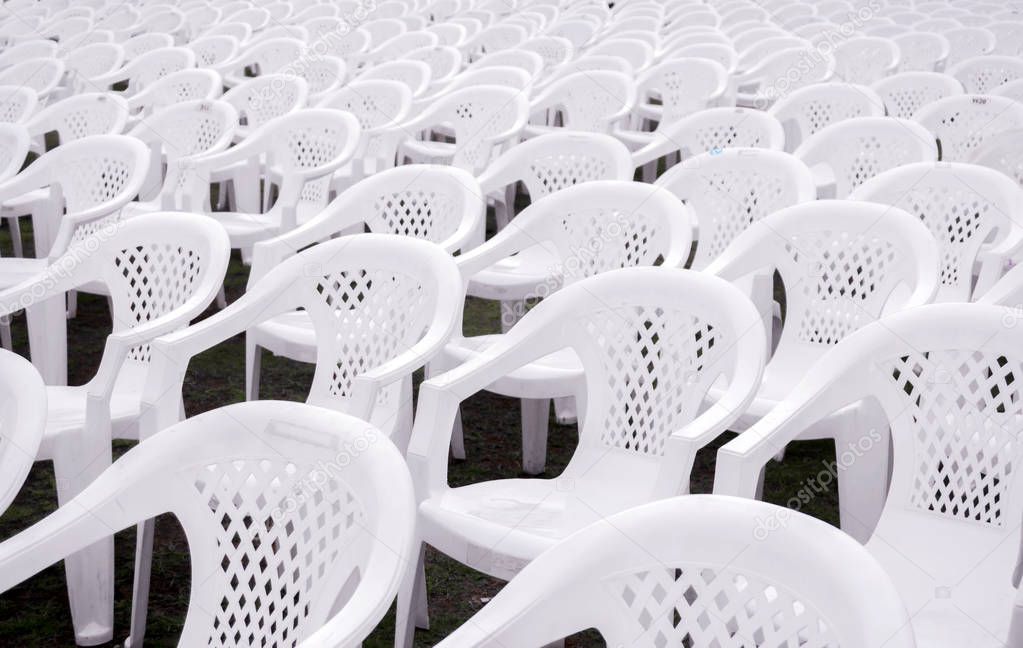 Closeup and crop white plastic chairs put on lined in rows for students in the graduation ceremony.