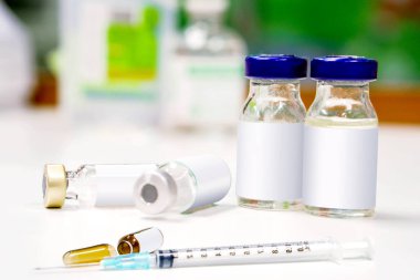 Örnek şişeleri ve plastik şırınga ile 3 ml. Ampul ampul bulanık arka plan beyaz tablo açıldığında.