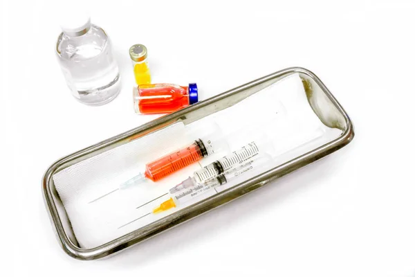 白い背景に患者への準備ができて注射のための医療用ステンレススチール製の容器に入れて医療用針とバイアルやプラスチック製の注射器でワクチン — ストック写真