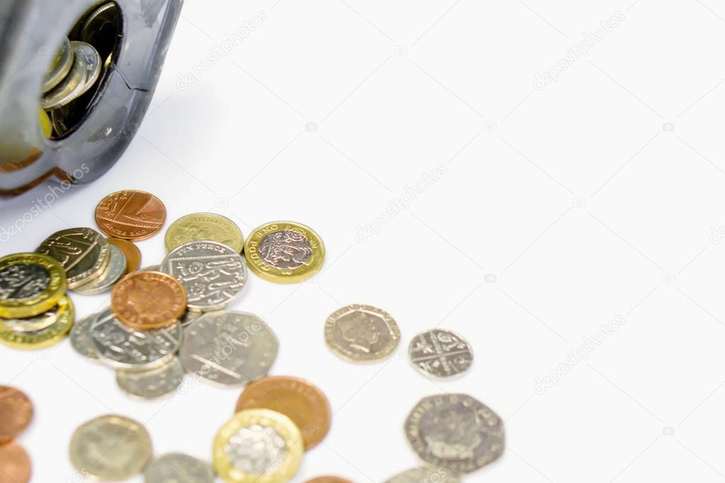 Closeup and crop British currency coins open from the piggy bank