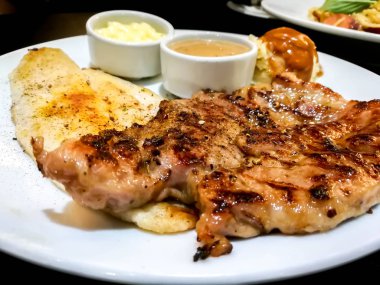 Kapalı domuz eti ve beyaz tabakta balık bifteği..