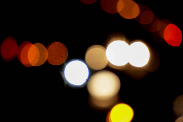 Abstract colorful bokeh reflection lighting on the road and black background.