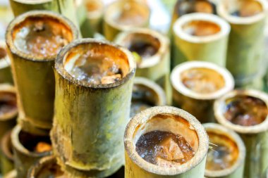 Tayland tatlısı-- (Krow Lam) Yanmış glutinous pilavı ile hindistan cevizi sütü ve buğulanmış Ginkgo fındığı ya da buharda pişirilmiş Taro 'nun bambu eklemlerinin üzerine konur..