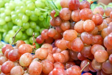 Süpermarkette satılık kırmızı ve yeşil üzümlerin yakın çekim ve mahsulü.