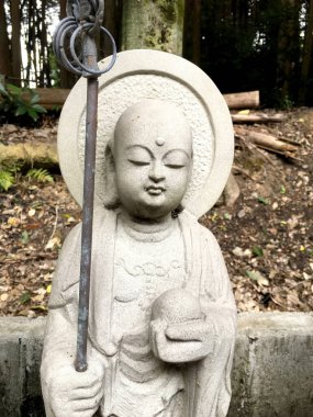 Japon tapınağındaki taştan oyulmuş Buda heykeli.
