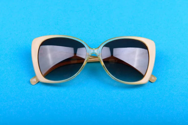 Жовті сонцезахисні окуляри на синьому фоні — стокове фото