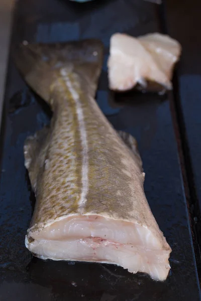 Bacalao en una bandeja negra —  Fotos de Stock