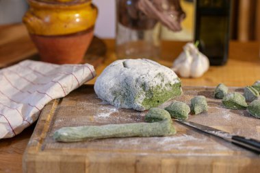 Tahta üzerinde gnocchi yapmak için ıspanak ezmesi.