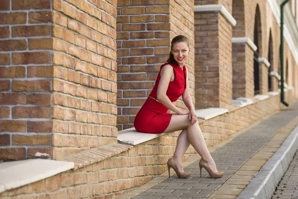 Estilo de vida retrato de uma bela jovem mulher vestindo vestido vermelho — Fotografia de Stock