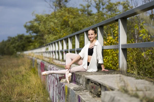 Attraktiva Ballerina poserar på ledstång utomhus — Stockfoto
