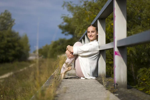 Krásná baletka sedící u zábradlí venkovní — Stock fotografie