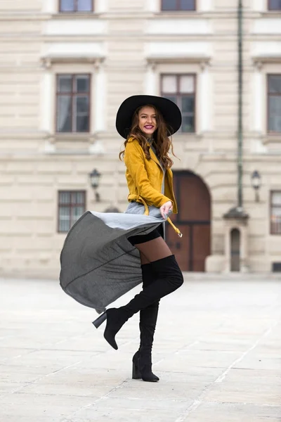 Estilo de vida retrato de uma jovem mulher vestindo jaqueta de couro amarelo e botas de joelho — Fotografia de Stock