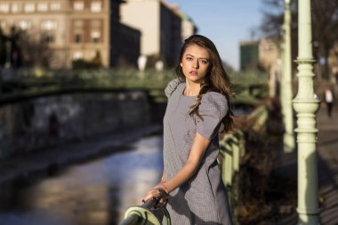 Bir şehirde bir nehir yanında duran şık kadın