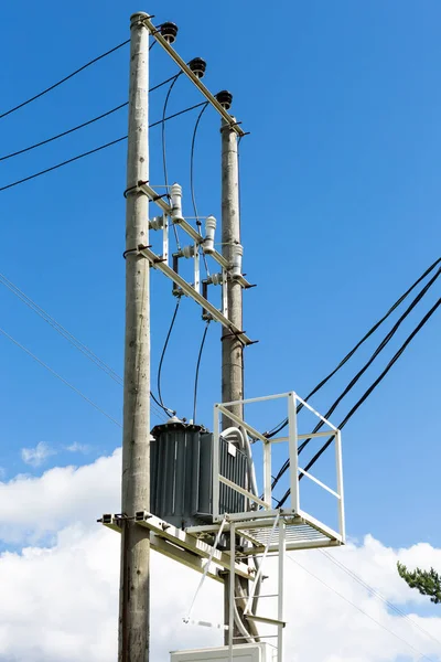 Transformer with the electricity poles in the field.