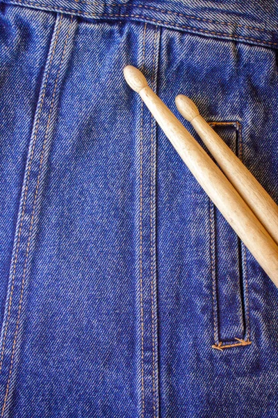 Дві барабанні палички лежать на джинсовому текстилі — стокове фото