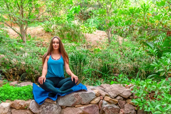 Young woman practicing yoga in the parck — Stock Photo, Image