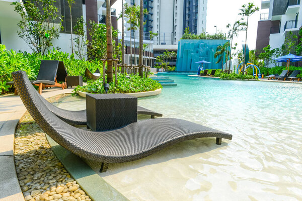 Beach chairs in luxury swimming pool.