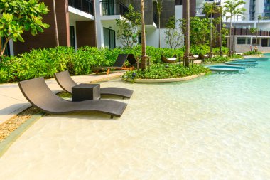 Plaj sandalyeleri lüks yüzme havuzunda.