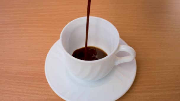 In Zeitlupe Kaffee in eine weiße Tasse gießen. — Stockvideo