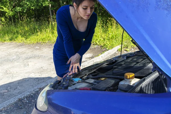 Giovane donna vicino rotto auto ha bisogno di assistenza guardando sotto cappuccio aperto. Concetto assicurazione auto — Foto Stock